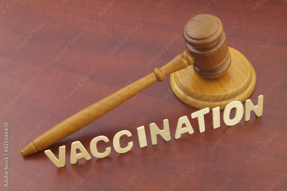Wooden judge gavel and word vaccination on table. Law and vaccination concept. Wooden judge gavel and word vaccination on table. Law and vaccination concept.