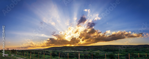 Panor  mica de atardecer en las monta  as con campo verde y alambrado con postes 