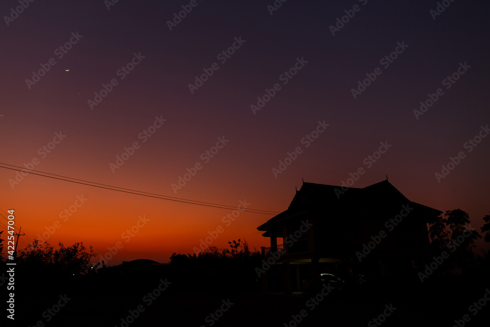 A silhouette of house under twilight sky. A silhouette of house under twilight sky.
