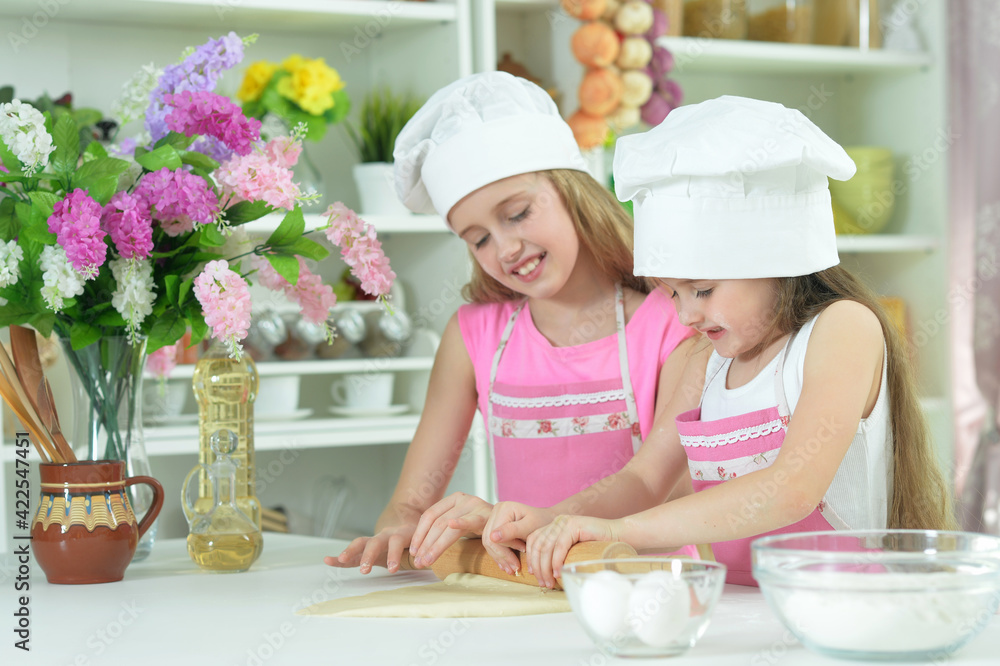 Cute little girls in hats making dough Cute little girls in hats making dough