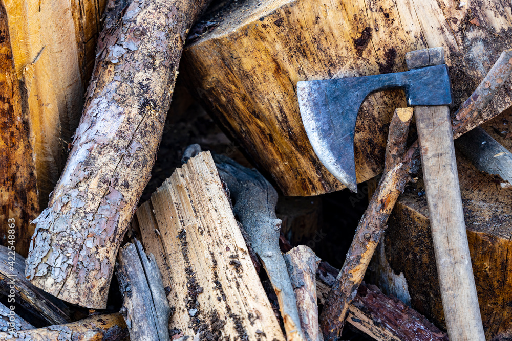 Heap of cut logs for firewood with an ax Heap of cut logs for firewood with an ax