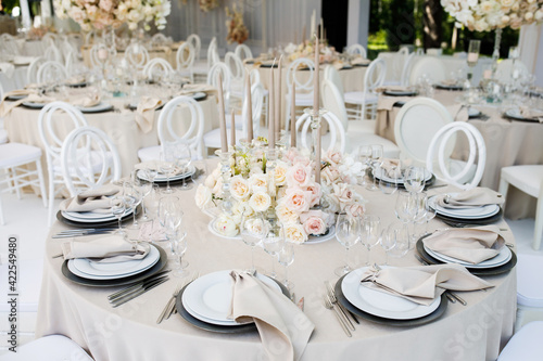 Festive wedding table setting with flowers, napkins, cutlery, glasses, bright summer table decor. Wedding decor