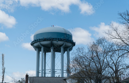 Obraz na płótnie Generic water tower sits high above residential homes in suburban neighborhood to provide clean drinking water pressure to houses w salonie