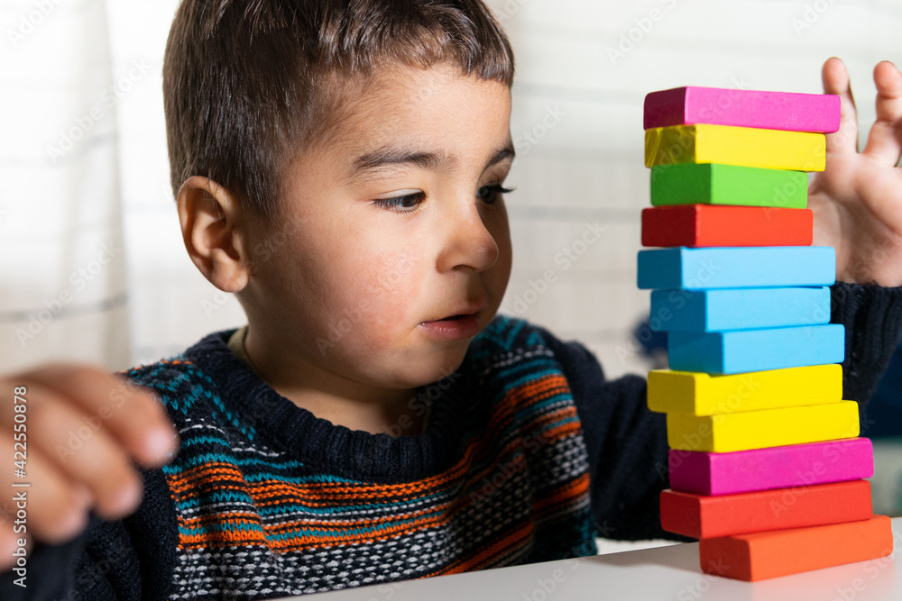 Fototapeta premium Child playing building blocks. Playing and learning at home. Building blocks. Creativity concept.
