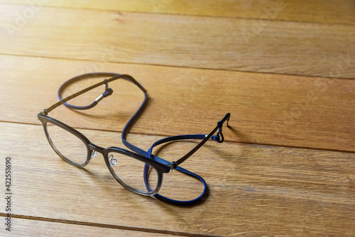 Clear Eyeglasses Glasses transparent dark blue Frame Vintage Style with neck strap on Wood Background