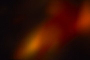 Blur colorful warm rainbow light leaks on black background with dust texture. Defocused abstract damaged scratched retro film analog effect for using over photos as overlay or screen filter