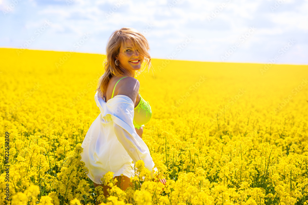 Happy woman running through yellow rapeseed field Happy woman running through yellow rapeseed field