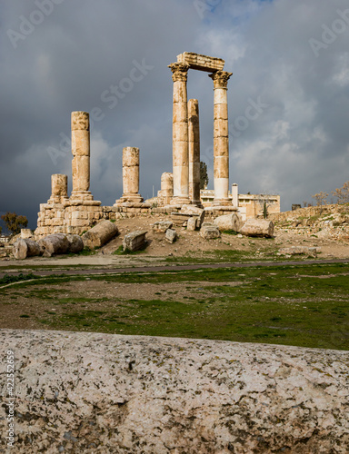 View of the ruins of the temple of Hercules on the top of the mountain of the Amman citadel against the background of a dramatic sky with clouds