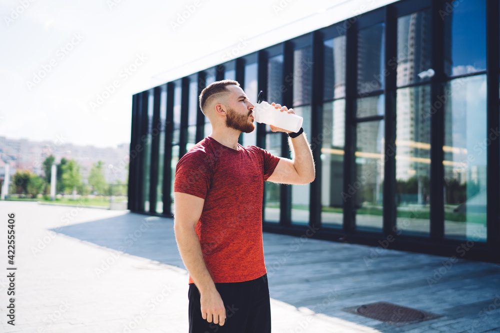 Sporty man drinking water on street Sporty man drinking water on street