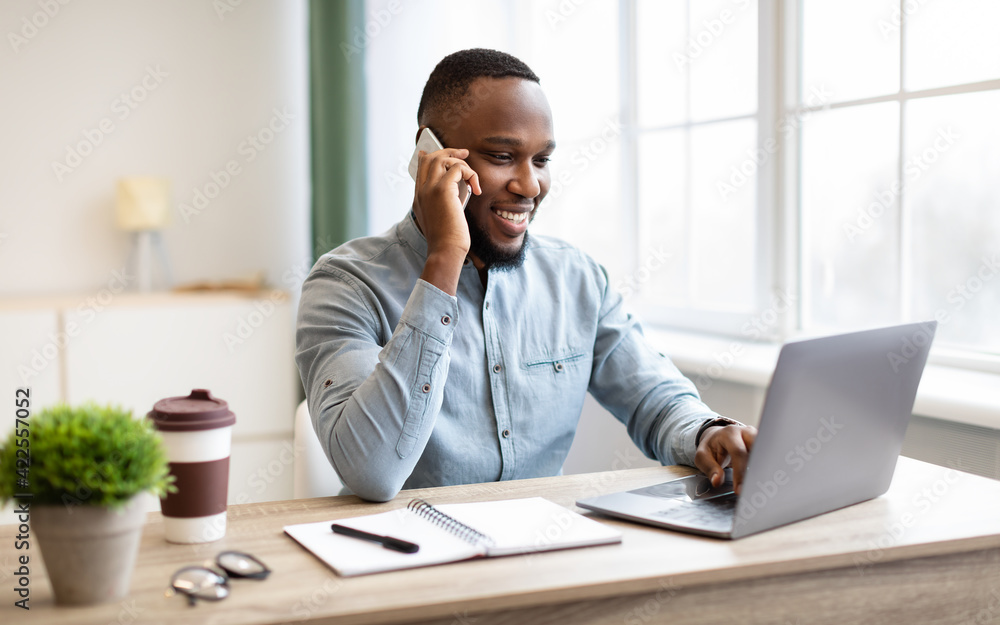 Obraz premium Happy African American Businessman Talking On Cellphone In Modern Office