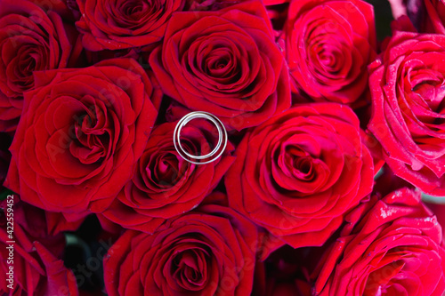 the wedding rings on bouquet of red roses