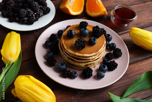 Tasty breakfast. Pancakes with blueberries and blackberries close-up on rustic wooden table