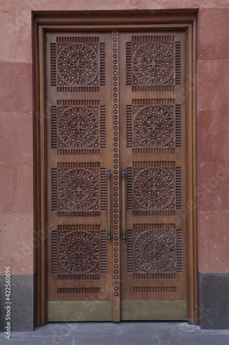 Vintage carved wooden ornamental door of Holy Transfiguration Cathedral of Armenian monastery complex of Moscow. Cathedral of Armenian Apostolic Church on Olimpiysky Avenue, 9, Moscow city, Russia photo