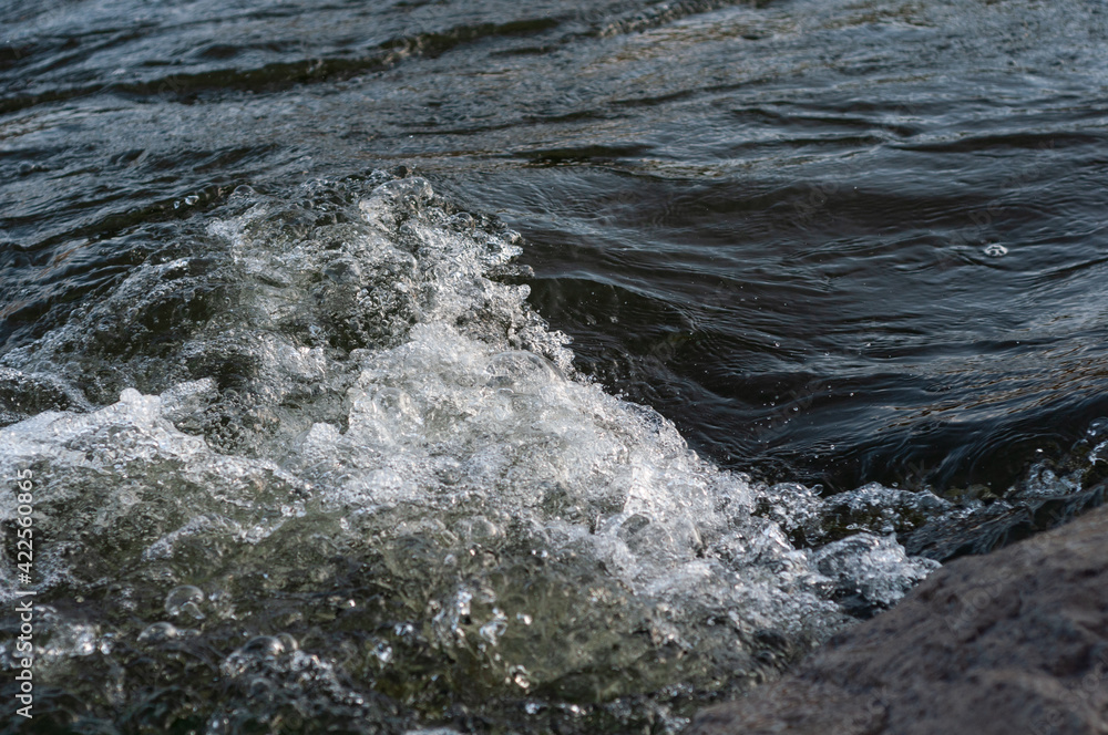 Background, top view, rapid flow river with dark blue water and white foam waves Background, top view, rapid flow river with dark blue water and white foam waves