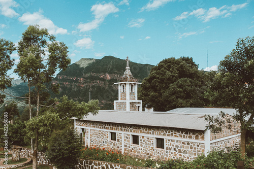 una iglesia sobre un monte rodeado de selva photo