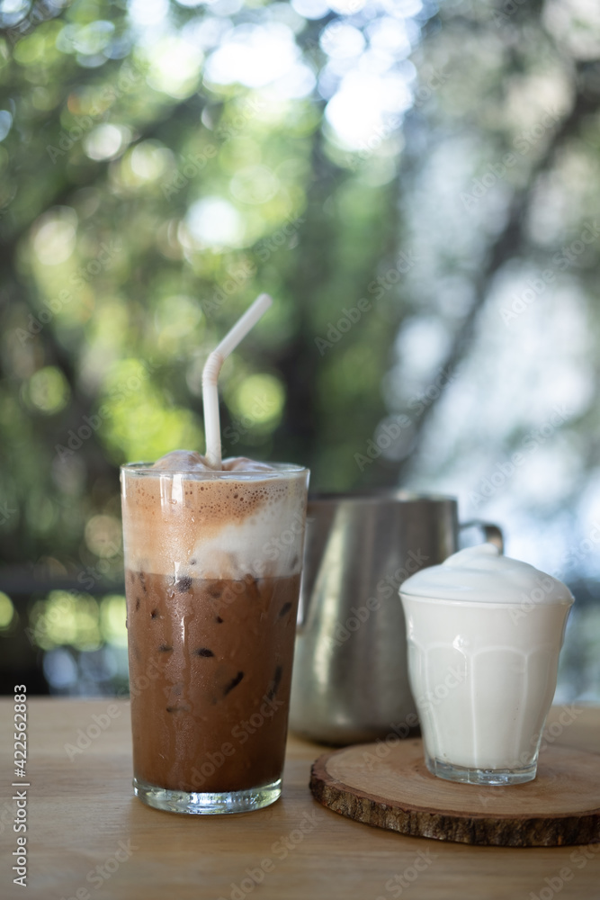 Iced Mocha coffee topping with milk foam and served with milk foam in glass Iced Mocha coffee topping with milk foam and served with milk foam in glass