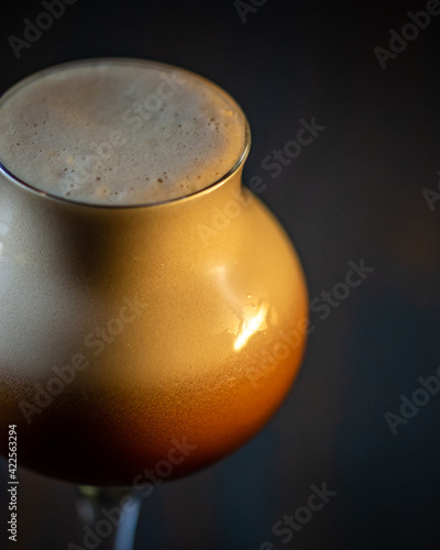 dettaglio di bicchiere da liquore, con schiuma densa marrone al caffè photo