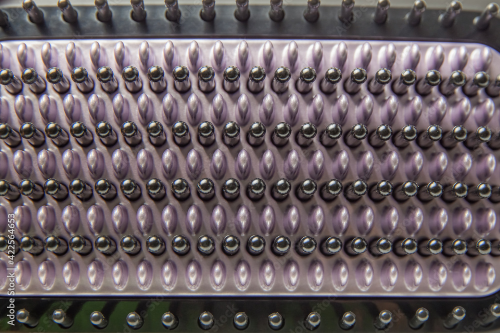 Black and purple bristles of an electric heat brush for straightening hair close-up