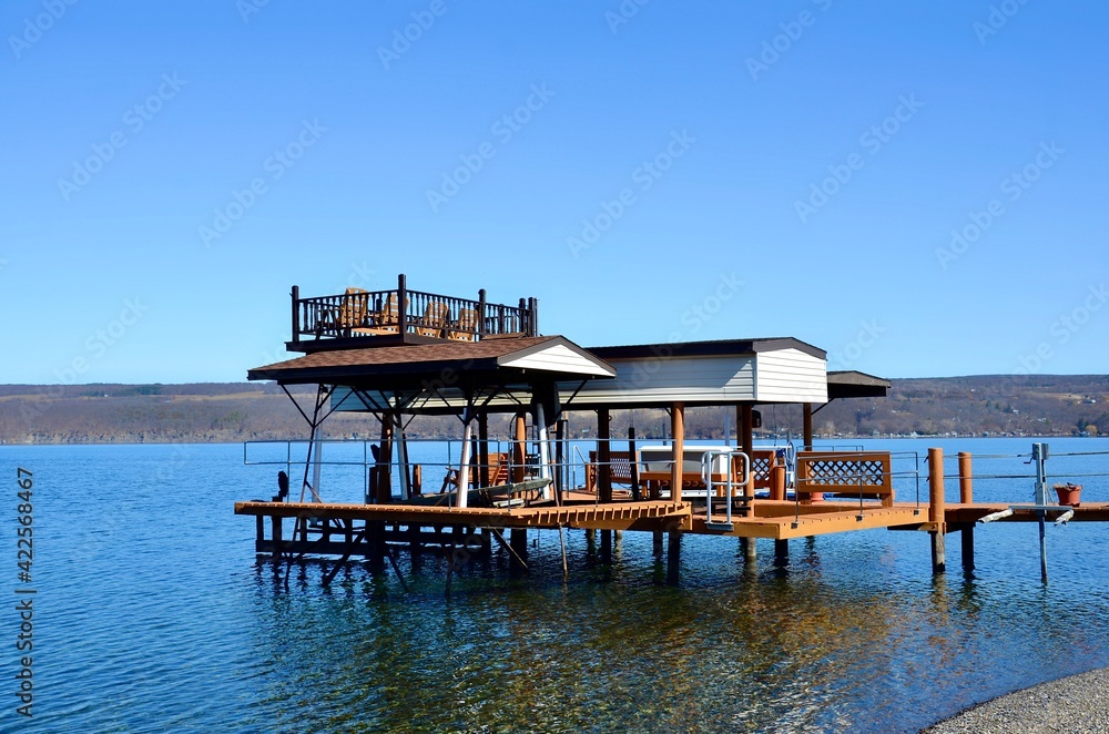 Beautiful wooden pier in the Seneca Lake, New York. It contains two levels with upper patio deck, for recreational activities Beautiful wooden pier in the Seneca Lake, New York. It contains two levels with upper patio deck, for recreational activities