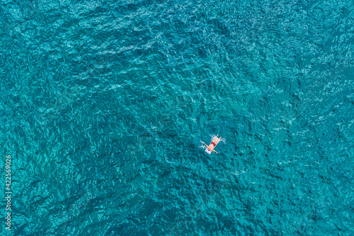 Man floating on the surface of clear blue sea © e_polischuk