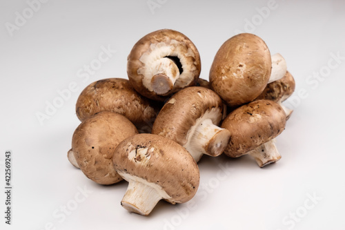 Pilze: Eine Handvoll natürliche braune Champignongs auf einem weißen Hintergrund (lat.: Agaricus bisporus)