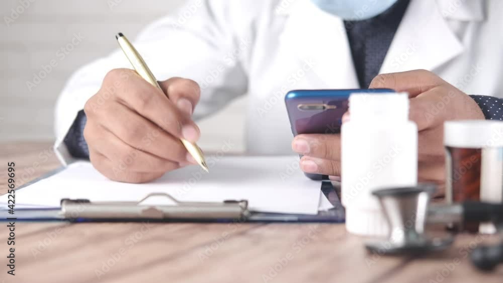 doctor hand writing prescription on desk, close up. doctor hand writing prescription on desk, close up.