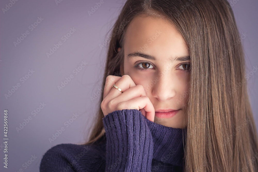 Portrait of a young brunette girl looking shy on purple background Portrait of a young brunette girl looking shy on purple background