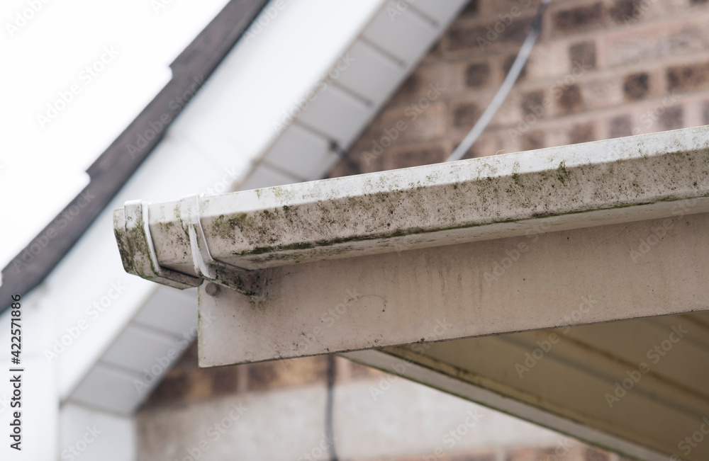 Foto de Dirty clogged white plastic pvc gutters and drain pipes with