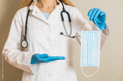 Image of female doctor showing surgical mask.	