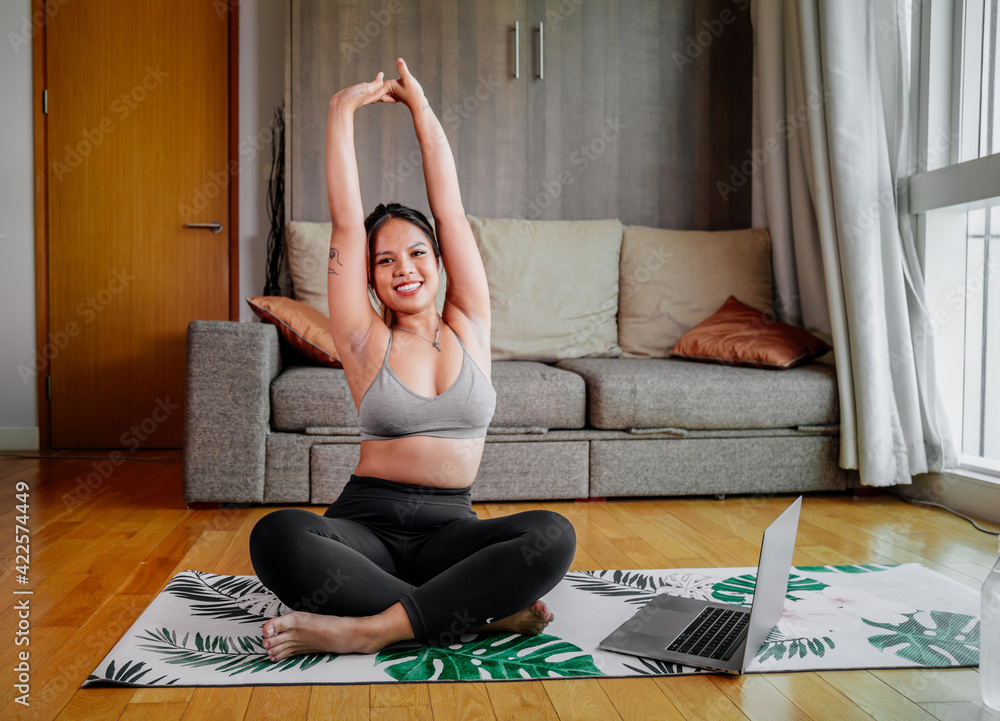 Young Asian healthy woman workout at home, exercise looking at videos, fit, doing yoga, plank, abs, meditation. Bodyweight floor exercises. Healthy lifestyle. Home fitness concept Young Asian healthy woman workout at home, exercise looking at videos, fit, doing yoga, plank, abs, meditation. Bodyweight floor exercises. Healthy lifestyle. Home fitness concept