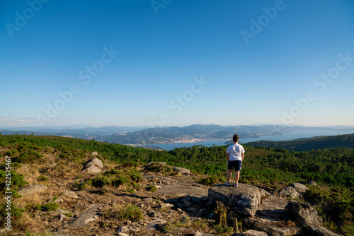 Hombre y niño mirando el mar desde la montaña y el bosque