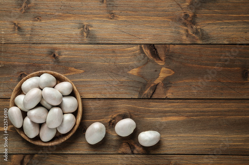 Raw jackfruit seeds on wooden table, flat lay. Space for text