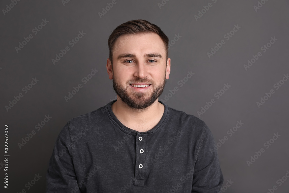 Obraz premium Portrait of happy young man on grey background. Personality concept