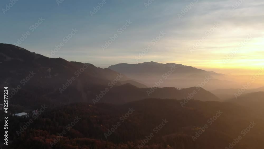 Aerial drone panoramic horizon mist view of a beautiful mountain landscape silhouette at sunset Aerial drone panoramic horizon mist view of a beautiful mountain landscape silhouette at sunset