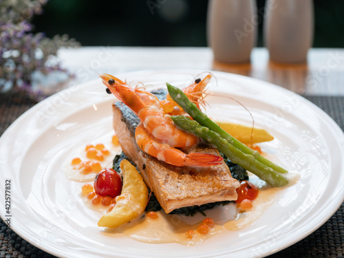 Western Menu - grilled salmon topped with a creamy white sauce served with spinach and asparagus
