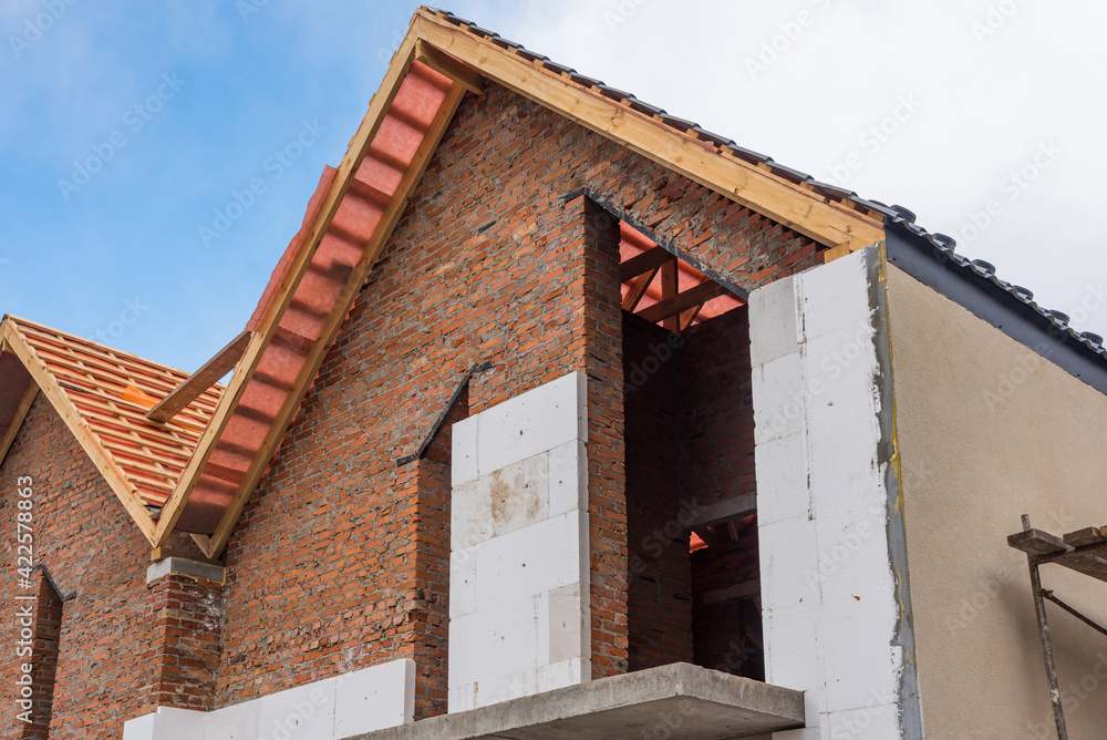 Unfinished house of brick, still under construction, installing roof, wall insulation. Unfinished house of brick, still under construction, installing roof, wall insulation.