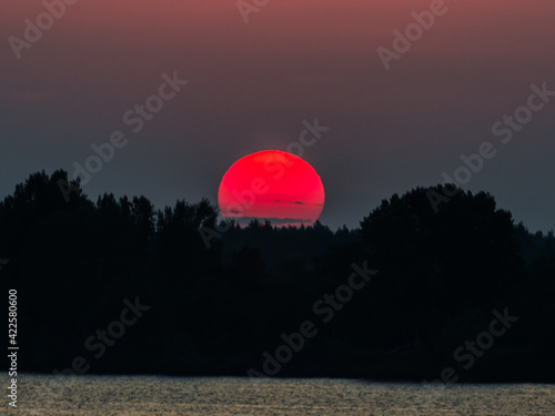 red sun at sunset, river photo