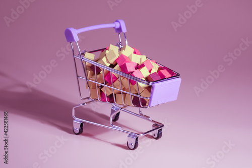 Shopping cart with wooden blocks, top view, closeup. Modern retail and commerce concept