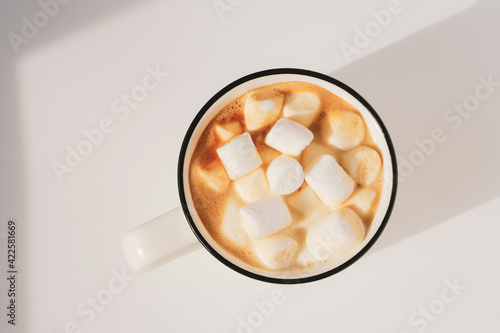 Coffee cup with marshmallow. Closeup, top view, copy space. Sunny atmospheric morning minimalistic concept