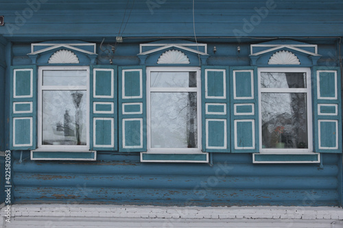 Ornamental carved windows, frames on blue traditional national old wooden rural house in Gorodets city, Russia. Russian folk style in architecture. Gorodets architectural monument, Gorodets landmark photo