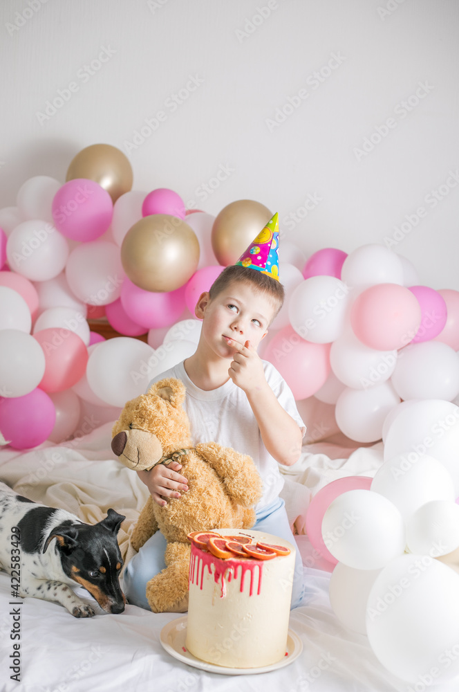 Fototapeta premium Little boy in white balloons with him dog. Small child with party balloons, celebration. Birthday, happiness, childhood, look.