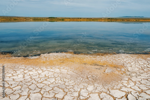 The shore of a salt lake in Tuva with salt on the shore of soil erosion