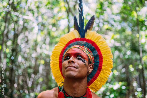 Indian from the Pataxó tribe, , with feather headdress. Young Brazilian Indian looking to the left. focus on faceIndian from the Pataxó tribe, with feather headdress.  photo