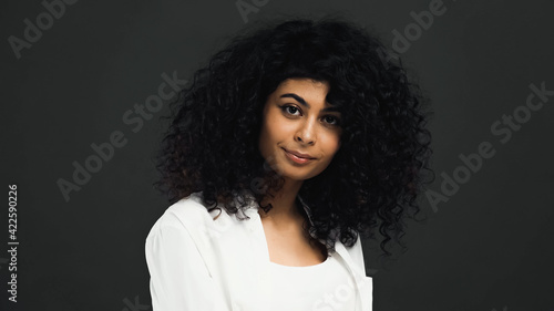 Young hispanic woman looking at camera isolated on black