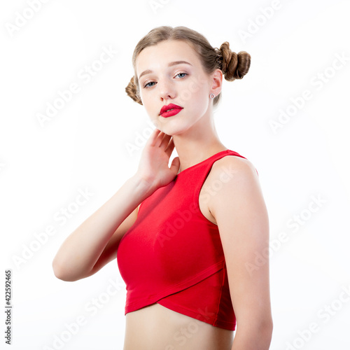 Canvas Print Young charming woman wearing red top posing at studio over white background