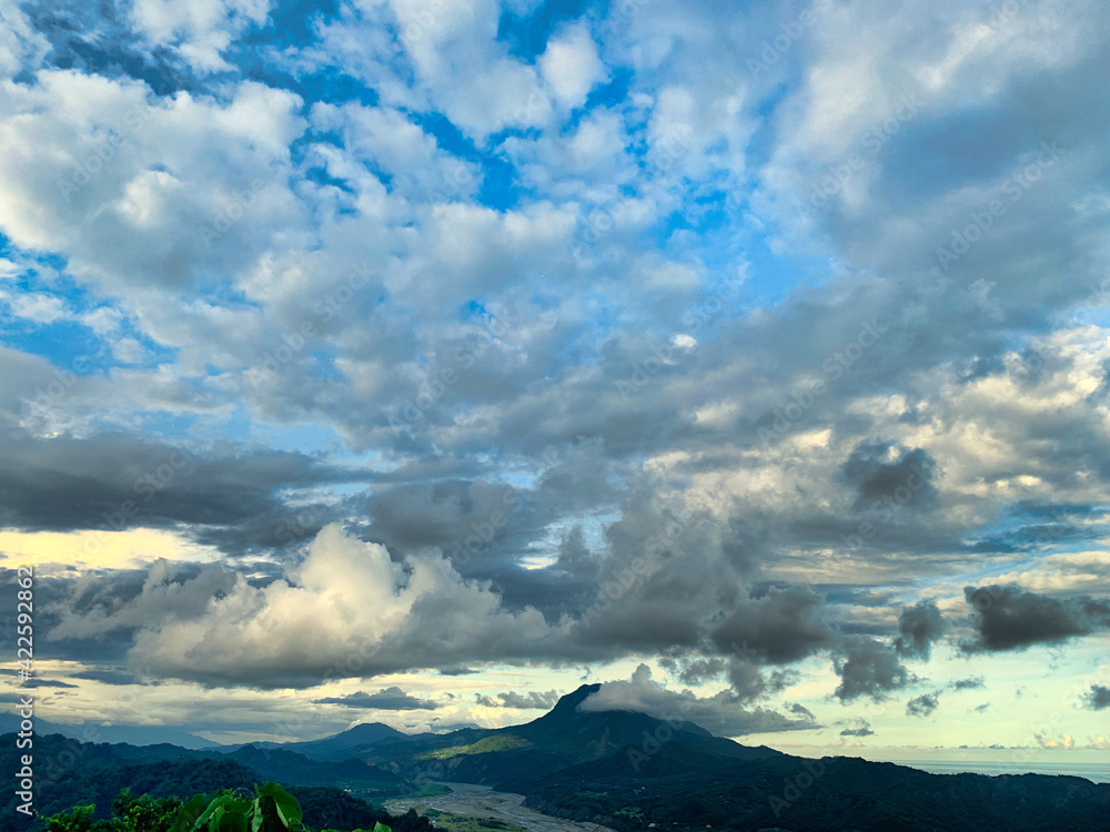 Landscape photo taken at Seige Mountain at Taitung, Taiwan focusing on cloudy sky at sunset time, and overlooking Beinan River and ridge of Central Mountain Range      