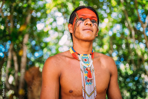 Indian from the Pataxó tribe smiling. Brazilian Indian from southern Bahia with necklace and traditional facial paintings looking to the left photo