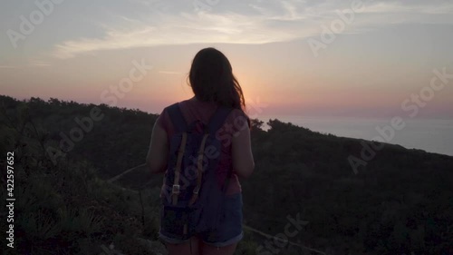 Wallpaper Mural Woman with a backpack in a mountain watching the sunset in the sea. Sun flares in her hair. Torontodigital.ca