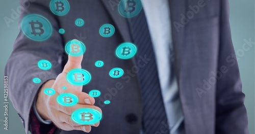 Composition of network of digital bitcoin icons over hand of businessman