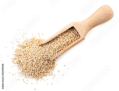 Quinoa in a wooden scoop on a white background, isolated. The view from top